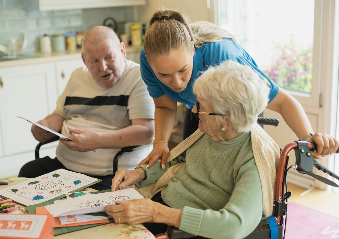 Caregiver sharing an activity with older adults at home